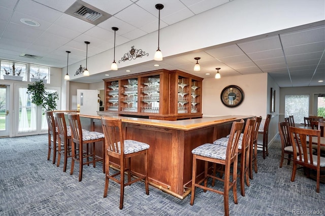 2945 W Riverwalk Cir Unit B, Littleton, CO 80123 - indoor dry bar with a drop ceiling, carpet flooring, healthy amount of natural light, and hanging light fixtures