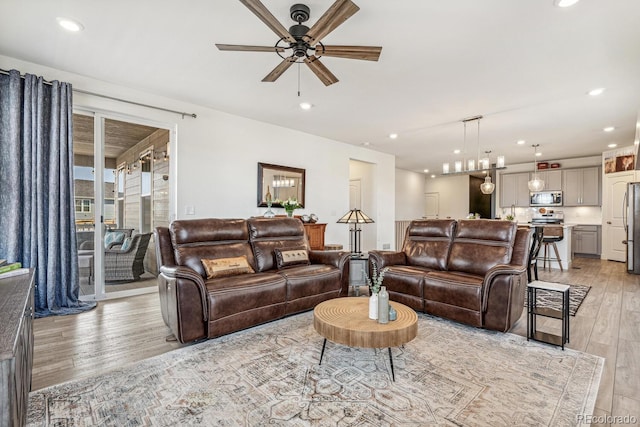 living area featuring recessed lighting, light wood-type flooring, and a ceiling fan