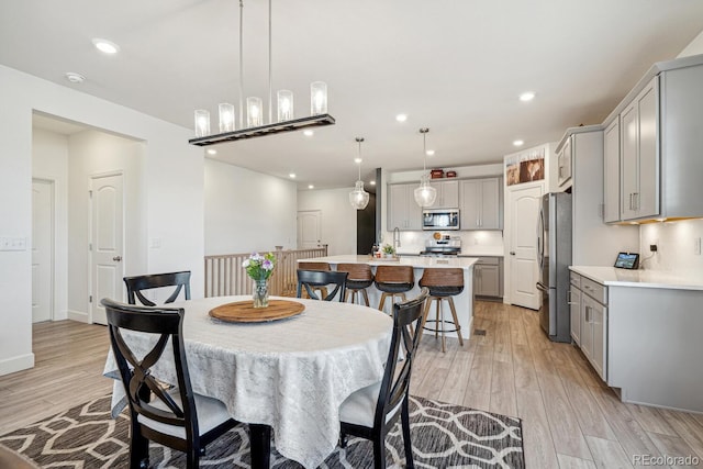 dining space with light wood finished floors, recessed lighting, and baseboards