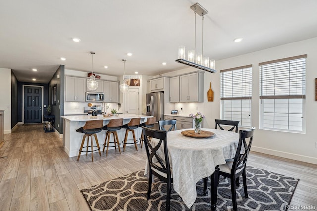 dining room with recessed lighting, baseboards, and light wood-style floors