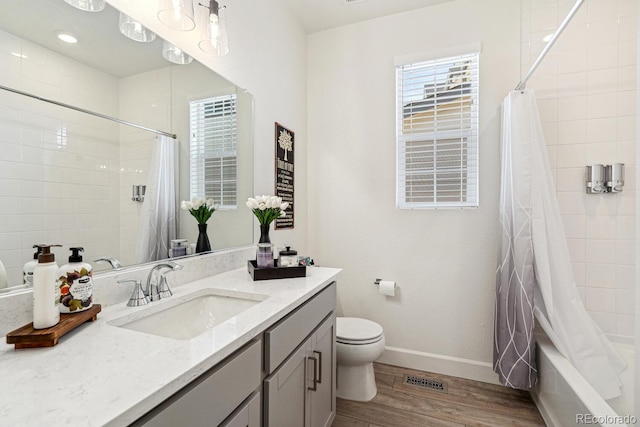 bathroom with vanity, wood finished floors, visible vents, baseboards, and toilet