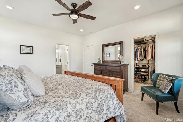 bedroom featuring a spacious closet, recessed lighting, a closet, and light carpet