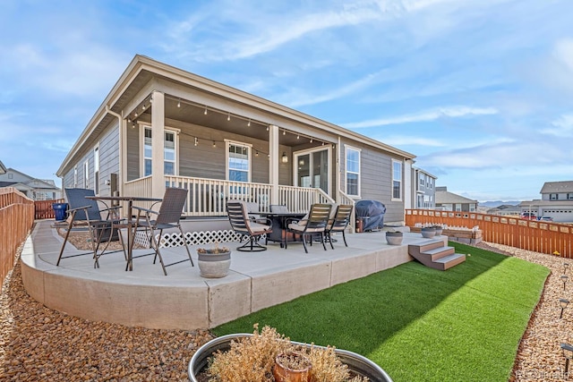 rear view of property with a lawn, a patio, and a fenced backyard