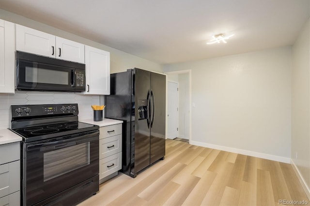 740 Lotus Way, Broomfield, CO 80020 - kitchen with black appliances, light countertops, decorative backsplash, light wood finished floors, and white cabinets