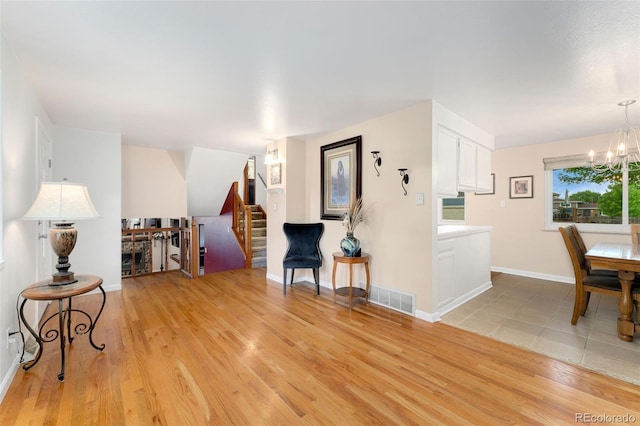 6798 Depew St, Arvada, CO 80003 - living area featuring a chandelier, light wood-type flooring, and stairway