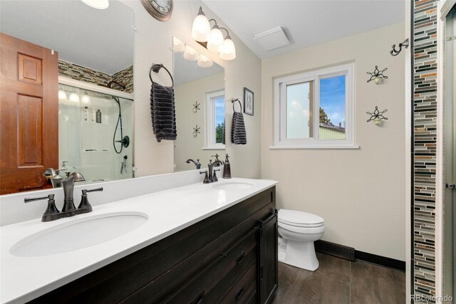 6798 Depew St, Arvada, CO 80003 - bathroom featuring a shower with shower door, wood finished floors, and double vanity