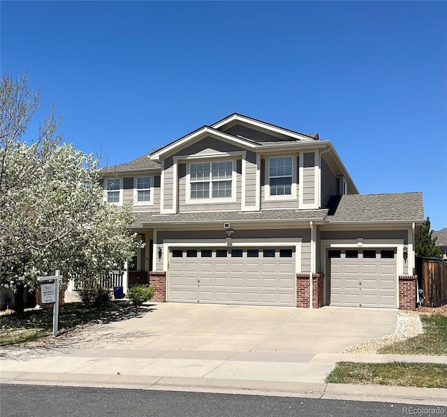 craftsman inspired home featuring a garage, fence, concrete driveway, and brick siding