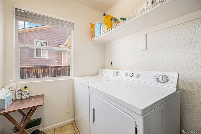 washroom featuring baseboards, separate washer and dryer, laundry area, and light tile patterned flooring