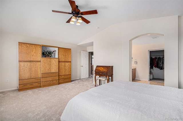 bedroom with visible vents, lofted ceiling, light carpet, baseboards, and arched walkways