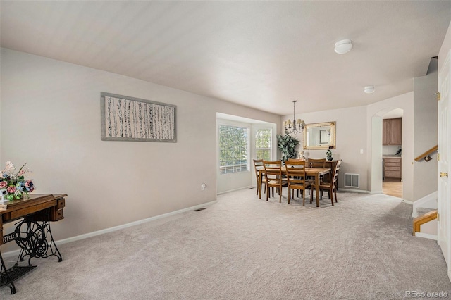 carpeted dining space with stairs, arched walkways, baseboards, and visible vents