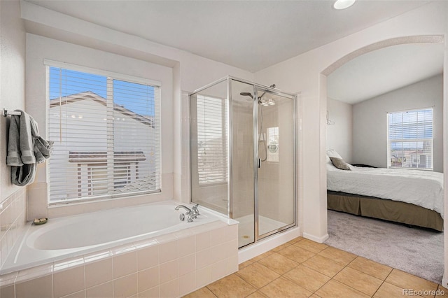 full bathroom featuring a bath, a stall shower, tile patterned floors, lofted ceiling, and ensuite bathroom