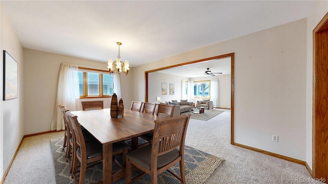 dining room with baseboards, a healthy amount of sunlight, an inviting chandelier, and light colored carpet