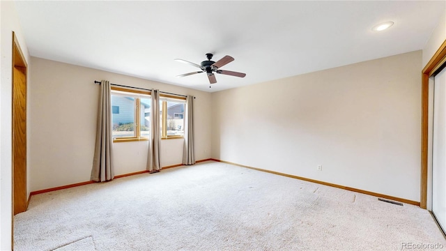 unfurnished room with visible vents, ceiling fan, light carpet, and baseboards