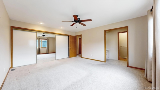 unfurnished bedroom with ensuite bathroom, light colored carpet, visible vents, baseboards, and a closet