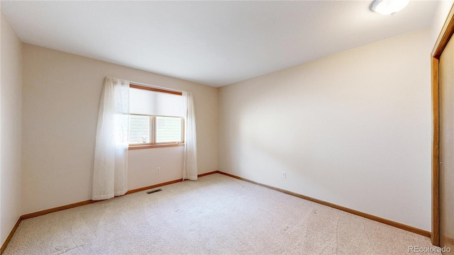 unfurnished room featuring carpet, visible vents, and baseboards