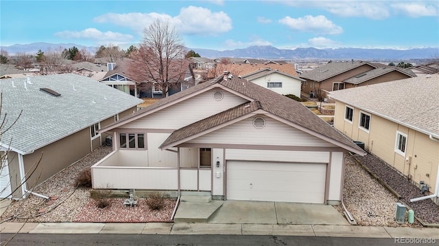 view of front of house with driveway, a garage, a mountain view, and a residential view