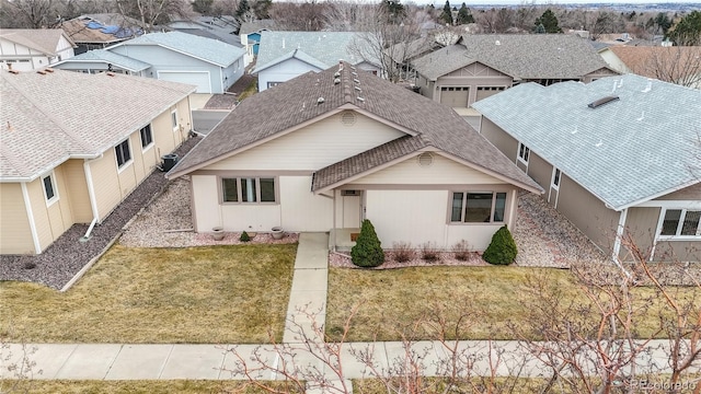 view of front of property featuring a shingled roof, a residential view, central AC, and a front lawn