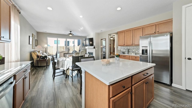 kitchen with a center island, dark hardwood / wood-style floors, appliances with stainless steel finishes, and tasteful backsplash