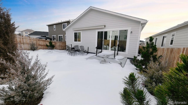 view of snow covered rear of property