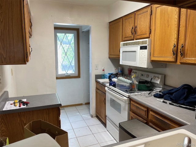 8181 S Fillmore Cir, Centennial, CO 80122 - kitchen featuring white appliances, brown cabinets, light tile patterned floors, and baseboards