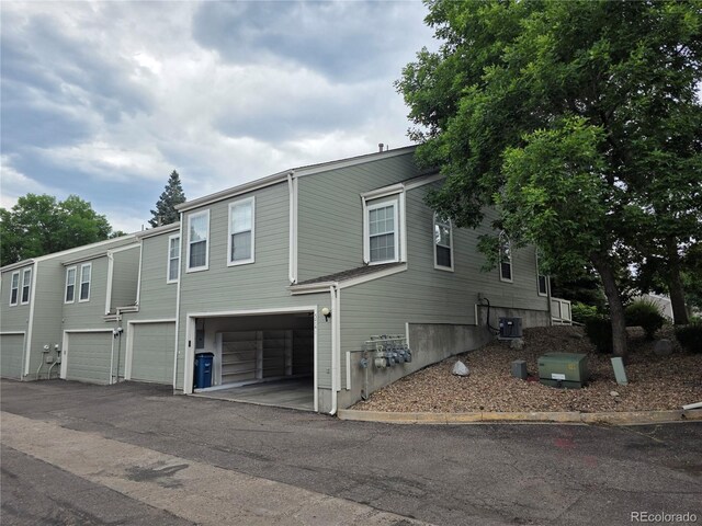 5741 W Asbury Pl, Lakewood, CO 80227 - view of property exterior with an attached garage and driveway