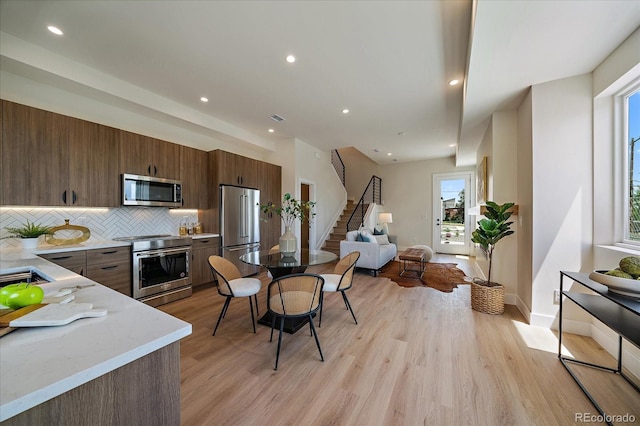 1372 Lowell Blvd Unit 1, Denver, CO 80204 - kitchen with appliances with stainless steel finishes, decorative backsplash, open floor plan, light wood-style floors, and recessed lighting