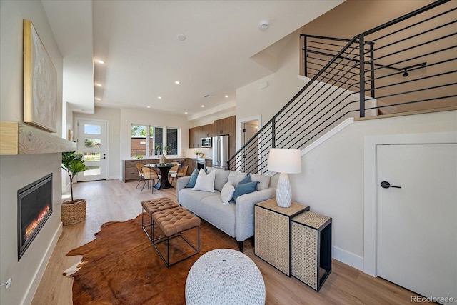 1372 Lowell Blvd Unit 1, Denver, CO 80204 - living room featuring light wood finished floors, stairs, a lit fireplace, baseboards, and recessed lighting