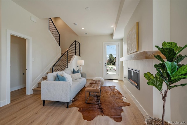 1372 Lowell Blvd Unit 1, Denver, CO 80204 - living area featuring light wood-type flooring, stairway, baseboards, a glass covered fireplace, and recessed lighting