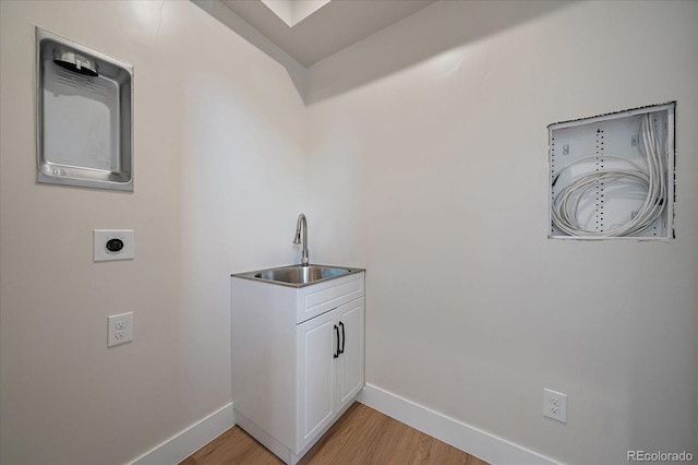 1372 Lowell Blvd Unit 1, Denver, CO 80204 - washroom featuring a sink, electric dryer hookup, baseboards, and light wood-style flooring