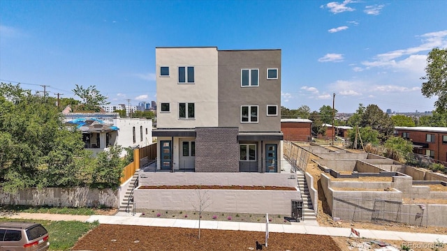 1372 Lowell Blvd Unit 1, Denver, CO 80204 - rear view of property featuring stairway, a vegetable garden, and stucco siding