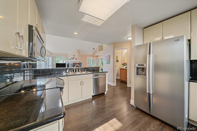 9346 W Coal Mine Ave, Littleton, CO 80123 - kitchen featuring appliances with stainless steel finishes, a peninsula, dark wood finished floors, recessed lighting, and dark stone counters