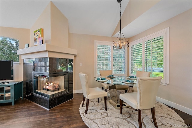 9346 W Coal Mine Ave, Littleton, CO 80123 - dining space with vaulted ceiling, a fireplace, dark wood-style floors, and a chandelier