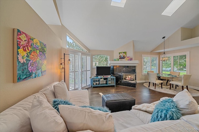 9346 W Coal Mine Ave, Littleton, CO 80123 - living room featuring plenty of natural light, wood finished floors, a high end fireplace, high vaulted ceiling, and a skylight