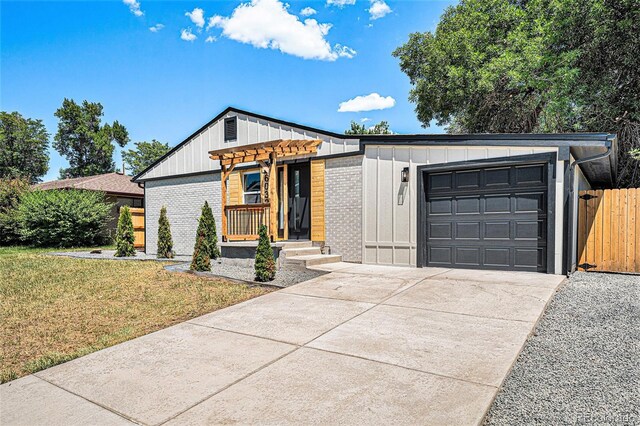 6032 Estes St, Arvada, CO 80004 - view of front of home with board and batten siding, an attached garage, brick siding, and concrete driveway