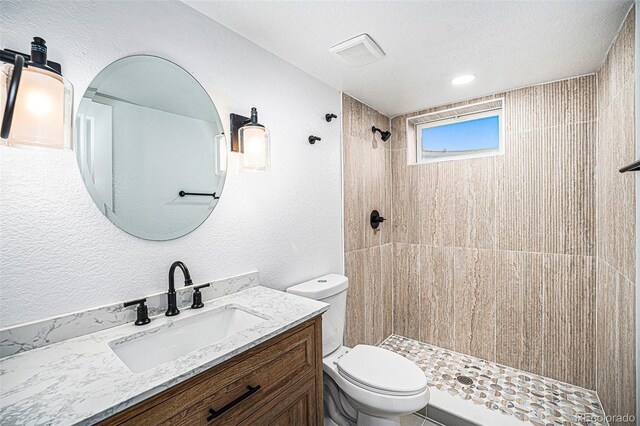 6032 Estes St, Arvada, CO 80004 - full bathroom with vanity, a tile shower, a textured wall, and a textured ceiling