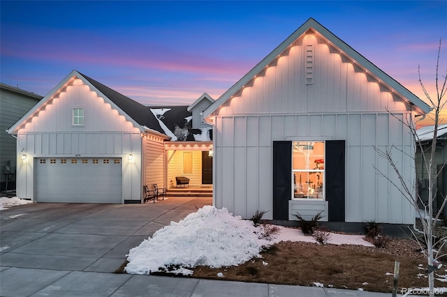 modern farmhouse with a garage, driveway, and board and batten siding