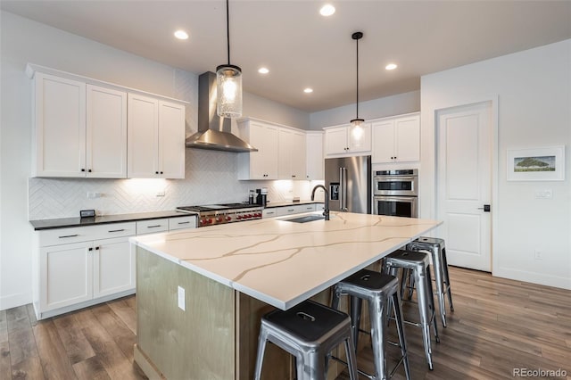 kitchen featuring appliances with stainless steel finishes, white cabinets, sink, and wall chimney exhaust hood