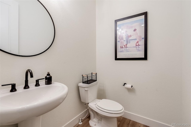 bathroom with toilet, hardwood / wood-style flooring, and sink