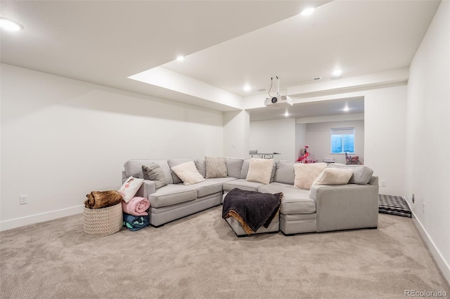 living room with a raised ceiling and light colored carpet