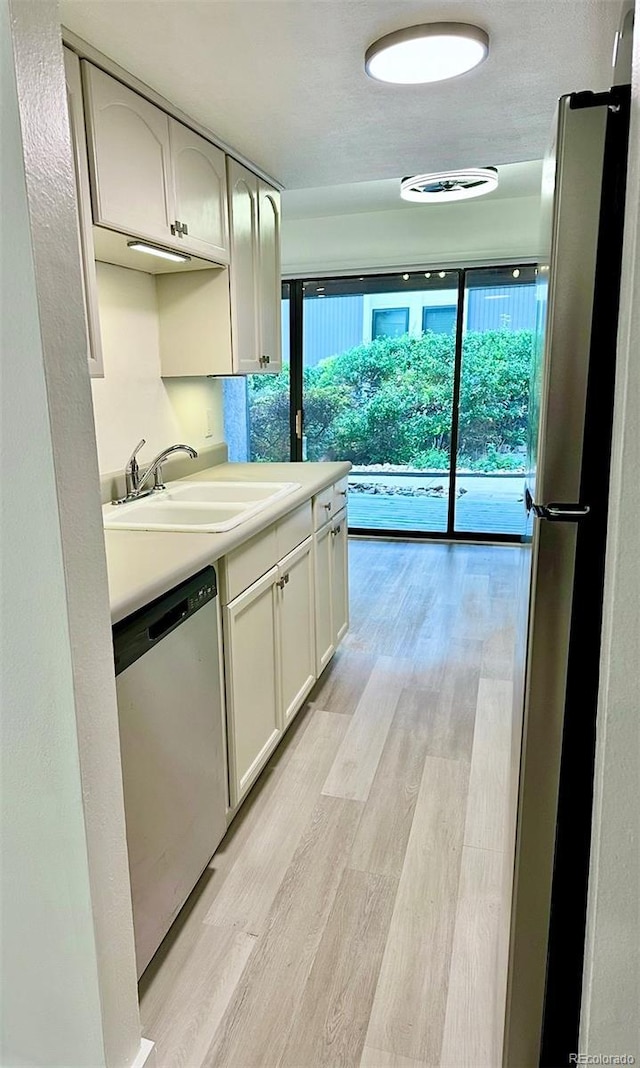 6480 S Dayton St Unit M04, Englewood, CO 80111 - kitchen with dishwasher, light wood finished floors, light countertops, and white cabinets