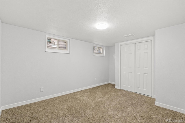 basement with carpet and a textured ceiling