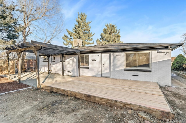 rear view of property featuring central AC unit, a deck, and a pergola