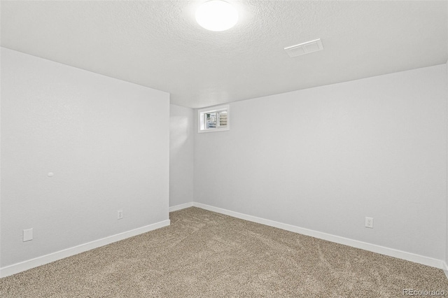 spare room with carpet flooring and a textured ceiling