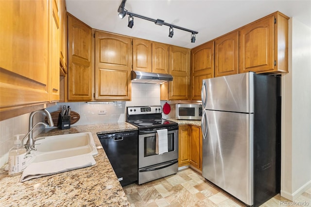 9320 E Center Ave Unit 4B, Denver, CO 80247 - kitchen with stainless steel appliances, under cabinet range hood, a sink, light countertops, and brown cabinetry