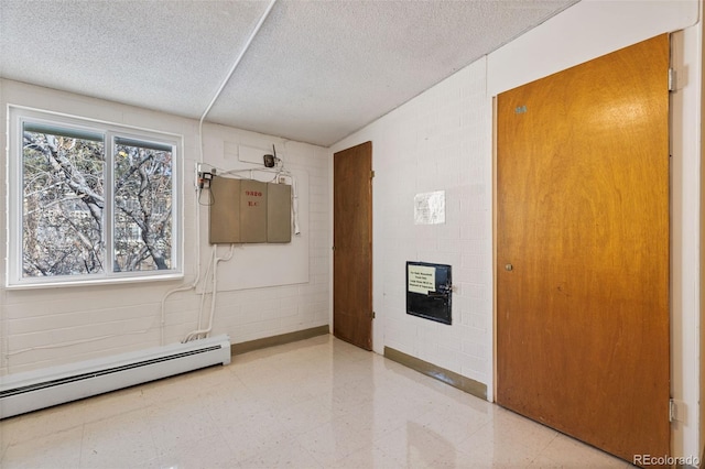9320 E Center Ave Unit 4B, Denver, CO 80247 - corridor with concrete block wall, a baseboard heating unit, a textured ceiling, and light floors