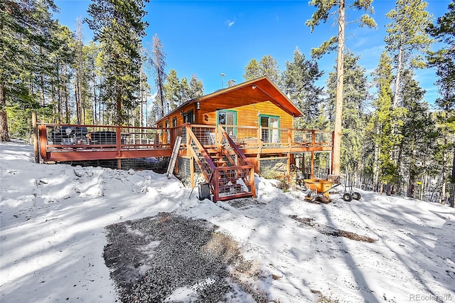 snow covered house with a deck