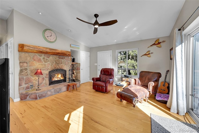 living room featuring hardwood / wood-style flooring, ceiling fan, a fireplace, and vaulted ceiling