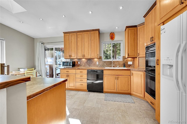 kitchen featuring sink, white fridge with ice dispenser, black dishwasher, and a wealth of natural light