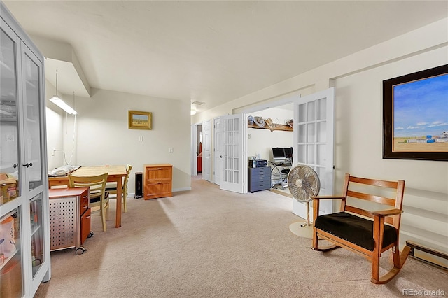 sitting room featuring french doors and carpet