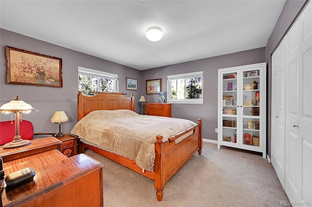 bedroom with multiple windows, a closet, and light colored carpet